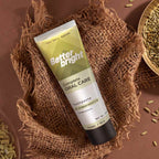 A tube of Better Bright Complete Oral Care Fennel mint toothpaste is displayed diagonally on a textured brown burlap cloth, surrounded by natural ingredients like fennel seeds in a wooden bowl.